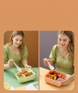 Κοντινό πλάνο ροζ και πράσινου lunch box με χωρίσματα και ασορτί μαχαιροπίρουνα