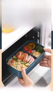 Deep blue lunch box with two compartments shown being placed in a microwave oven