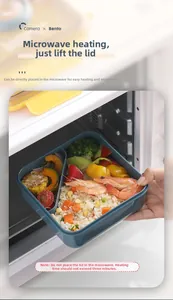 Blue-grey bento box with food showing microwave-safe heating in a modern kitchen