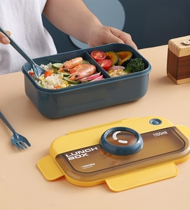 Detailed view of an 1100ml blue and yellow compartmentalized lunch box with utensils
