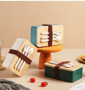 Trois boîtes à lunch minimalistes avec couvercles en bois et couverts à bandes élastiques