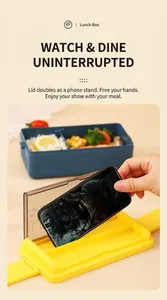 Detail of blue double-layer lunch box lid used as a phone holder with interior compartments