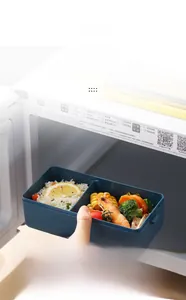 Blue dual-compartment lunch box being used inside a microwave for meal prep