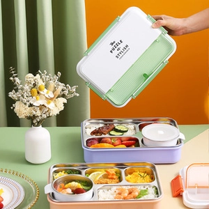 Close-up of divided stainless steel bento box with food and leak-proof soup bowl