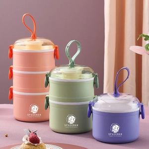 Three stacks of colorful Japanese bento boxes with spaceman design and loop handles