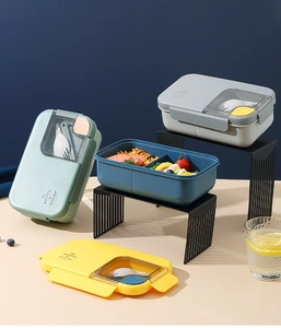 Detail of portable divided lunch box with transparent cutlery compartment and utensils