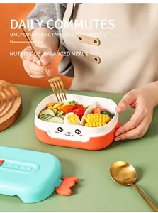 Close-up of divided cartoon lunch box with orange details and fresh vegetable sections