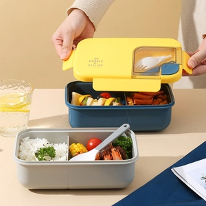 Japanese style bento lunch box with compartments and cutlery set on a dining table