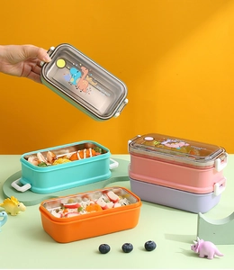 Stapel bunter zweischichtiger Edelstahl-Lunchboxen mit Dinosaurier-Motiven