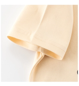 Détail de la couture double sur la manche d'un t-shirt en coton crème pour enfants