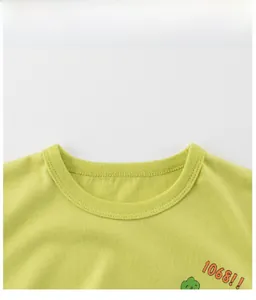Close-up of cotton baby T-shirt crew neck detail with orange logo and cartoon tree print