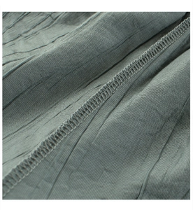 Detailed close-up of sage green crinkle fabric and high-quality overlock stitching