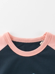 T-shirt raglan da bambina a maniche corte con colletto rosa e etichetta taglia 7/8