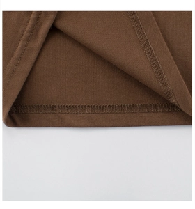 Detailed close-up of double-stitched hem on a dark brown cotton knit kid's t-shirt