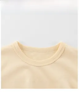 Detail of round ribbed neckline and Get Together print on yellow cotton t-shirt
