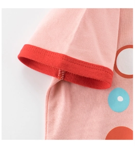 Détail d'un t-shirt rose en coton avec poignets côtelés rouges et coutures contrastées