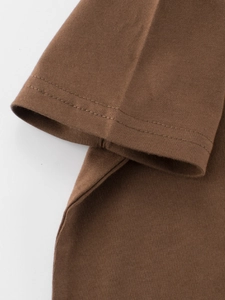 Close-up of sleeve cuffs on kids brown cotton T-shirt showing durable double-needle stitching
