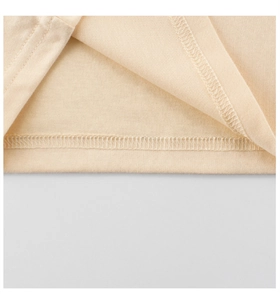 Close-up of double-needle hem stitching on cream cotton kids short sleeve t-shirt