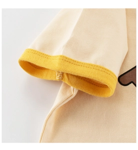 Détail du bord-côte jaune et de la double couture sur le tissu en coton crème