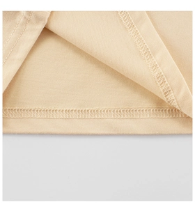 Gros plan des coutures précises et des détails de l'ourlet sur ce T-shirt en coton beige