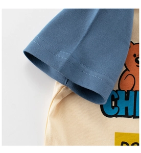 Détail de couture sur manche bleue et imprimé ours orange sur t-shirt pour bébé