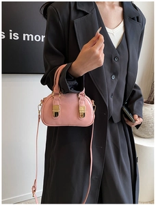 Detailed shot of a pink glossy leather bowling bag featuring elegant gold hardware locks