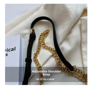 Detail of adjustable leather strap with gold buckle and chain for crossbody handbag