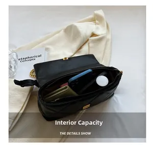 Detail view of the quilted leather interior capacity showing daily essentials with chain strap