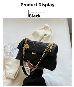 Detail of black quilted faux leather bag featuring a chunky gold chain and round charm
