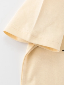 Close-up of beige cotton knit t-shirt for kids showing high-quality stitching and fabric