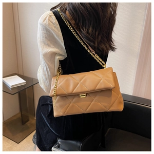 Close-up of caramel quilted chain bag showing the elegant rhombic stitching and gold strap
