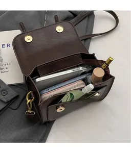Detail view of coffee brown retro crossbody bag showing multi-layer compartments and magnetic snaps