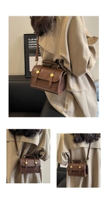 Detail of vintage brown leather crossbody bag featuring gold buckle and retro styling