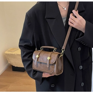 Chic vintage brown leather crossbody bag styled with a professional black blazer