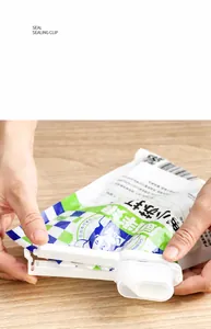 Close-up of food sealer clip with pour spout for snack bags on wooden desk
