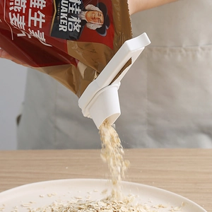 White plastic food bag sealing clip with large discharge spout pouring oatmeal cereal