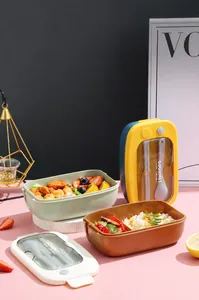 Detail view of the portable lunch box lid featuring a built-in cutlery storage and handle