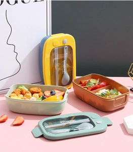 Detail view of the two-compartment lunch box with built-in cutlery storage and utensils