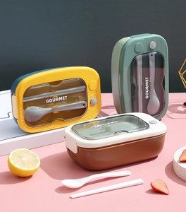 Detailed view of lunch box lids with transparent windows and integrated cutlery set