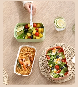 Three-piece stackable bento boxes in morandi colors on a light wooden table