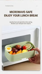 Close-up of a stackable green bento box with fresh food being heated in a microwave