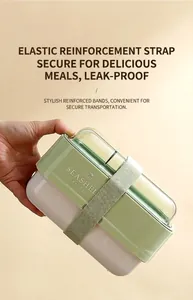 Detail view of double-layer lunch box with green elastic strap and airtight lid