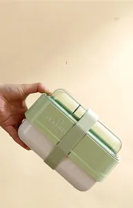 Detail view of double-layer lunch box with green elastic strap and airtight lid