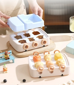 Detail view of a 6-cavity cartoon bear silicone ice cream mold with blue lid and ring handles