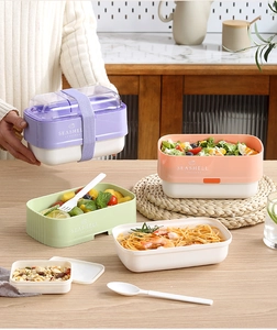 Close-up of colorful stackable lunch boxes with secure elastic straps and plastic cutlery