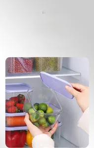 Close-up of stackable PET food storage boxes with purple lids inside a refrigerator