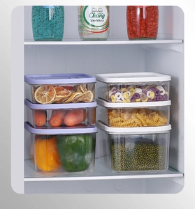 Vertical stack of clear PET food storage containers with airtight lids in refrigerator