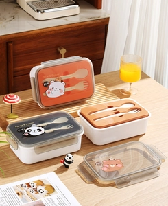Detalle de fiambrera bento con cierres laterales, cubiertos y dibujos de animales