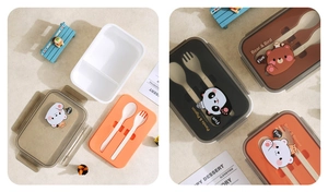 Detalle de fiambrera bento dividida con tapas de dibujos, incluye juego de cuchara y tenedor