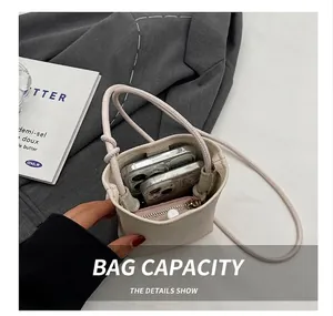 Detail view of mini off-white crossbody bag interior showing phone and wallet capacity